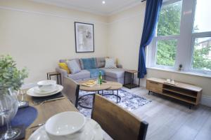 a living room with a couch and a table at The Bay View Stays - 2 Sleek Apartments by Parydise - Great for Families & Professionals in Morecambe