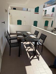 een zwarte tafel en stoelen op een balkon bij FAMILY HOUSE Letojanni Taormina in Letojanni