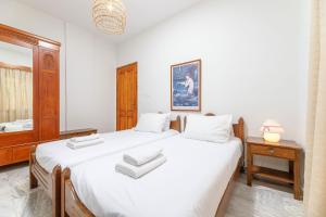 a bedroom with two beds and a mirror at Lyria Hotel Apartments in Stalos