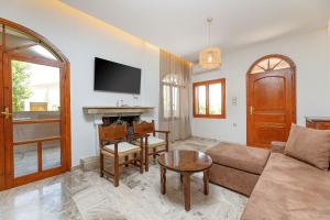 a living room with a couch and a fireplace at Lyria Hotel Apartments in Stalos