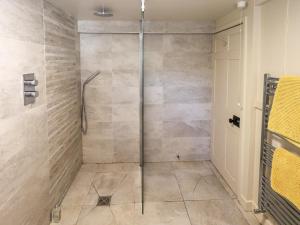 a shower with a glass door in a bathroom at Bridge End Cottage in Ulverston +36 photos