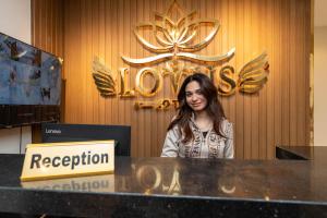 a woman sitting at a counter in front of a reception desk at Lotus Al-Tahrir hotel in Cairo