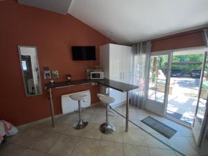 Una cocina con una mesa y taburetes en una habitación. en Dépendance individuelle, en Nans-les-Pins