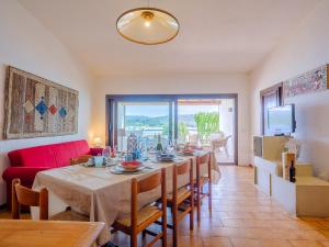 un soggiorno con un tavolo e un divano rosso di Sardinia Family Villas - 3 Bedrooms Apartment a Cannigione Altre 28 foto