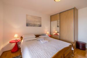 a bedroom with a large bed with two lamps at Apartments Nada in Trogir