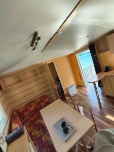 a room with a bed and a table with a skateboard on the ceiling at mobil home 4 personne 2 chambre vu lac a condes in Condes