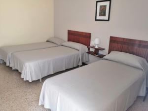 Posteľ alebo postele v izbe v ubytovaní Hostal Torre Mar