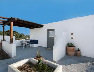 a white house with a patio with a table and chairs at Mykonos home Delphini in Mikonos