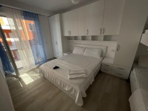 a small bedroom with a bed with white sheets at Shtepipushimi23 Rana e Hedhun in Shëngjin