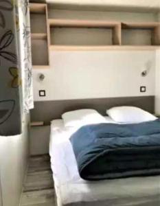 a bedroom with a bed with blue sheets and pillows at Camping 4 étoiles - Piscine - eecaad in Aureilhan +31 photos