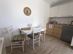 a small kitchen with a table and chairs in a room at Hacienda Natura Agroturystyka in Warlubie