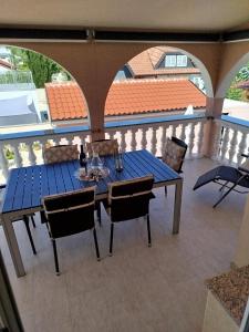 una mesa azul y sillas en un balcón con techo en Apartments Juric, en Privlaka