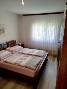 Un dormitorio con dos camas y una ventana. en Apartments Juric, en Privlaka