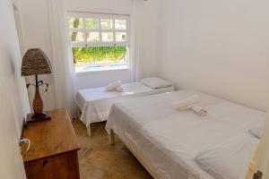 two beds in a room with a window at Casa com piscina privativa a 100m da Praia de Paúba in São Sebastião +69 photos