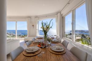 a dining room with a table with a view of the ocean at Villa Vista Mar in Santa Ponsa