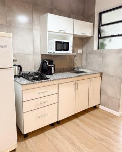 a kitchen with white cabinets and a microwave at Che Pampa Departamento in Santa Rosa