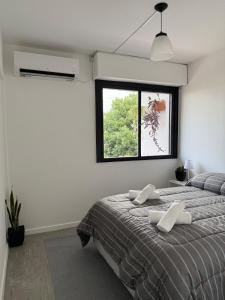 a bedroom with a large bed and a window at Che Pampa Departamento in Santa Rosa