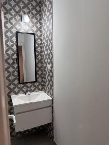 a bathroom with a sink and a mirror at Che Pampa Departamento in Santa Rosa +2 photos