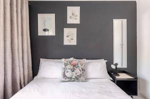 a bedroom with a bed with a flower pillow on it at Cozy loft with swimming pool in Johannesburg +9 photos