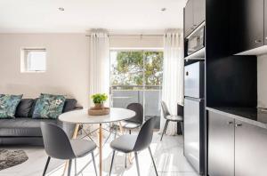 a kitchen and living room with a table and chairs at Cozy loft with swimming pool in Johannesburg