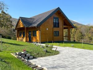 a large wooden house with a stone driveway in front of it at Wooden Villa Old Oak Plitvice Lakes in Seliste Dreznicko