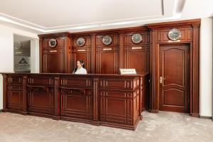 eine Frau, die an einem Schreibtisch in einem hölzernen Gerichtssaal sitzt in der Unterkunft Charos Family Resort in Yusufkhona + 27 Fotos