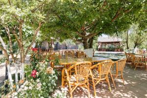 einen Holztisch und Stühle unter einem Baum in der Unterkunft Charos Family Resort in Yusufkhona