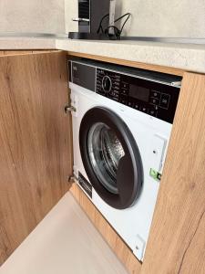 Una lavadora en una cocina debajo de un mostrador. en NARDIN Apartment, en Kavarna
