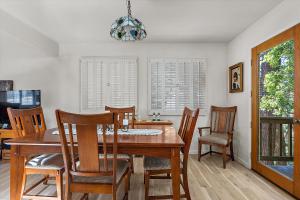 Un comedor con mesa y sillas de madera. en Holly Hill Cottage, en Cambria