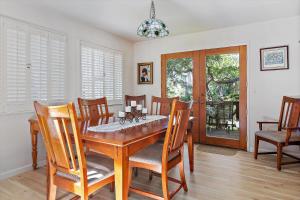 Un comedor con mesa y sillas de madera. en Holly Hill Cottage, en Cambria