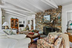 a living room with a couch and a stone fireplace at Home Sweet Home New Monthly in Cambria