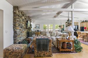 a living room with a couch and a stone wall at Home Sweet Home New Monthly in Cambria