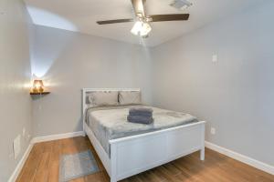 a white bedroom with a bed with a ceiling fan at 11 Mi to Dtwn Family Home in Houston! in Houston
