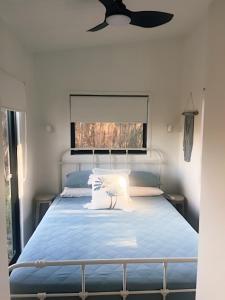a bedroom with a blue bed with a window at Milfarrago Farm Stay in Farnborough