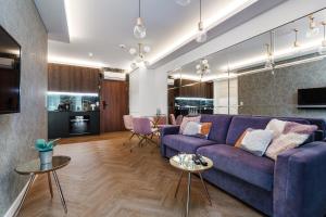 a living room with a purple couch and tables at Baltic Amber Apartment in Stegna