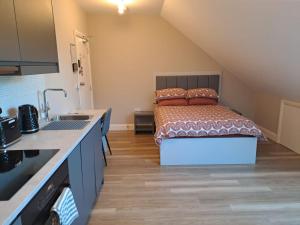 a kitchen with a bed and a sink in a room at Sands House - luxury modern studios with secure parking in Epsom, Surrey in Epsom
