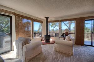 a living room with chairs and a table and windows at A Beautiful Tree Top Panorama in Cambria