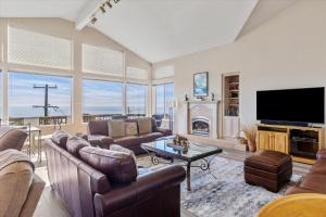 a living room with leather furniture and a tv at Dream Catcher in Cambria