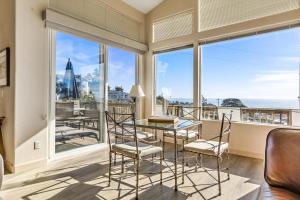 a dining room with a table and chairs and windows at Dream Catcher in Cambria