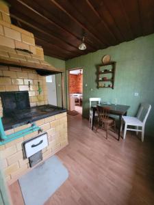 a kitchen with a stove and a table in a room at Domek Teremiski in Białowieża