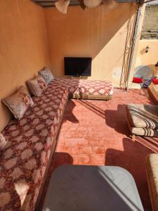 a bedroom with a bed and a flat screen tv at Riad Bennouna in Fez