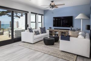 een woonkamer met twee witte banken en een tv bij Oceanfront Stella Maris in Cambria