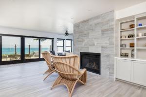 een woonkamer met een open haard en de oceaan bij Oceanfront Stella Maris in Cambria