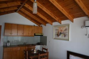 Una cocina con armarios de madera, una mesa y un fregadero. en Ionio Rooms II, en Himare 60 fotos más