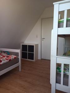 a bedroom with a bunk bed and a ladder at Landblick - idyllische Wohnung an der Nordsee in Simonsberg