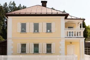 una gran casa amarilla con una valla blanca en Zu Hause in Tirol en Kirchbichl
