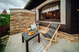 two chairs and a table on a patio at Dolina Wikingów-apartament typu Suite Deluxe z 16 m tarasem w ogrodzie, miejscem w garażu i dostępem do strefy Wellness in Szklarska Poręba