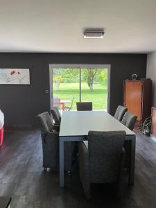 a dining room with a white table and chairs at Maison en rez de jardin in Pluvigner