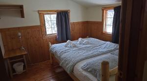 a bedroom with a bed with two pillows on it at Rustic Beaverfoot Lodge Room N6 in Parson