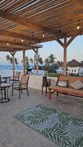a patio with a couch and tables and chairs at Zanzicrown in Nungwi